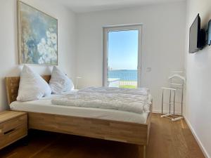a bedroom with a bed with a large window at Ferienwohnung eastside App 3 Olpenitz in Olpenitz