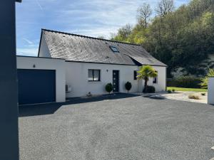 a white house with a garage and a driveway at L'Olivier de munet in Distré