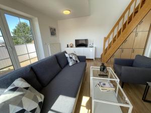 een woonkamer met een blauwe bank en een tafel bij Nautic W20 in Laboe