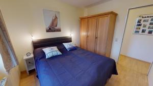 een slaapkamer met een bed met een blauw dekbed bij Hafenresidenz W09 in Laboe