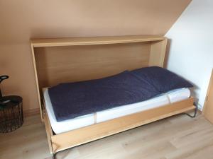 ein Bett mit einem Holzrahmen in einem Zimmer in der Unterkunft Feld PU1 in Laboe
