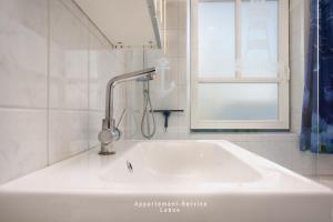 a white sink in a bathroom with a window at Fewo 4 Knotenpunkt in Laboe +6 photos