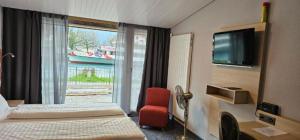 a hotel room with two beds and a television at The River Village in Interlaken