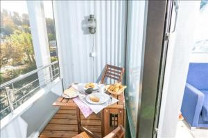 a table with a plate of food on a balcony at Fewo Mann in Laboe