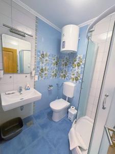 niebieska łazienka z toaletą i umywalką w obiekcie Villa in Seget w Trogirze