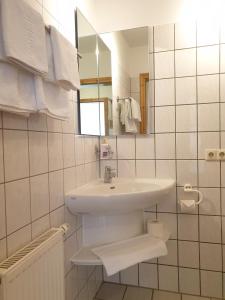 a white bathroom with a sink and a mirror at Fewo 13 Haus Neustein in Stein