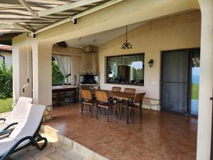 een open patio met een tafel en stoelen bij Private Villa 102 in BlackSeaRama in Balchik