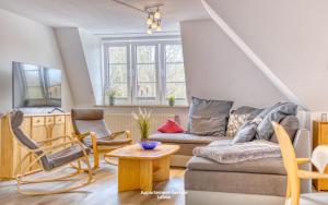 uma sala de estar com um sofá e uma mesa em Wiesenweg W14 em Laboe