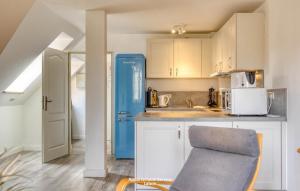 uma cozinha com um frigorífico azul num quarto em Wiesenweg W14 em Laboe