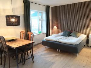 克内贝尔Mols Bed & Breakfast的一间带床和桌子的卧室和一间餐厅