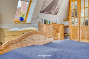 um quarto com uma cama, uma cómoda e janelas em Wiesenweg W14 em Laboe