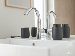a kitchen sink with two cups and a faucet at Hausboot Floating Homes - A-Type Laboe FH-LA-03 Baltic Bay in Laboe