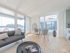 a living room with a couch and a table at Hausboot Floating Homes - A-Type Laboe FH-LA-03 Baltic Bay in Laboe