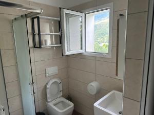 uma pequena casa de banho com um WC e uma janela em Hotel Tepelena em Tepelenë