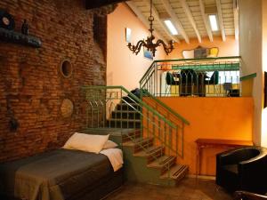 Pokój z klatką schodową z łóżkiem i klatką schodową w obiekcie Pasaje Solar w BuenosAires