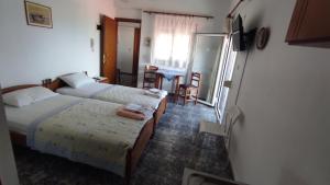 a bedroom with two beds and a table and a desk at Peristerianos apartments in Nea Skioni