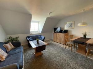 a living room with a blue couch and a table at Wiesenweg W16 in Laboe