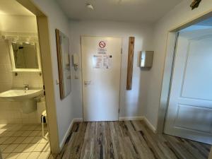 a bathroom with a toilet and a sink and a door at Wiesenweg W16 in Laboe +11 photos