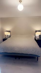 Giường trong phòng chung tại Sentralt i rolig bygård, med heis, egen, veranda & 85" Smart TV