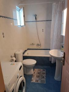a bathroom with a tub and a toilet and a sink at EVITA apartment in Preveza +13 photos
