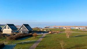eine Gruppe von Häusern auf einem Feld mit einem Fluss in der Unterkunft Leuchtfeuer in Wendtorf