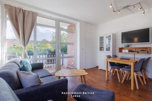 una sala de estar con un sofá y una mesa en Hafenresidenz Fördeglück, en Laboe