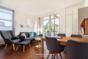 Una sala de estar con una mesa y sillas y un sofá. en Hafenresidenz Fördeglück, en Laboe