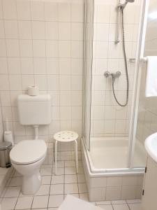 a white bathroom with a toilet and a shower at Wiesenweg W09 in Laboe