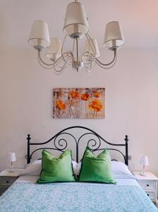 1 dormitorio con 1 cama con 2 almohadas verdes en Affittacamere Chiti Melania en San Gimignano
