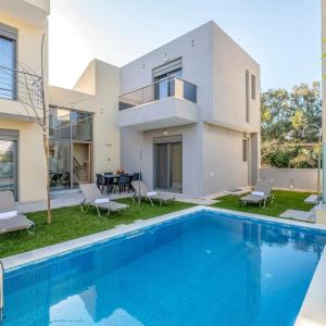 a villa with a swimming pool in front of a house at Park-View Pool Villa in Chania Town