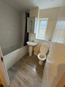 a bathroom with a toilet and a sink at Arden Place in Thamesmead +5 photos