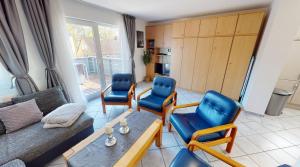 a living room with blue chairs and a couch at Appartement-Service-Laboe Haus Seewind in Laboe