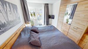 a bedroom with a large bed with pillows on it at Appartement-Service-Laboe Haus Seewind in Laboe