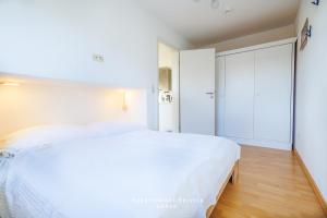 ラーボエにあるBellevue W06の白いベッドルーム(大型ベッド1台、クローゼット付)