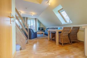 a living room with a dining room table and chairs at Bellevue W10 in Laboe