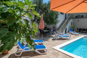 una piscina con un grupo de sillas y una sombrilla en Apartment Marina on the second floor, en Makarska