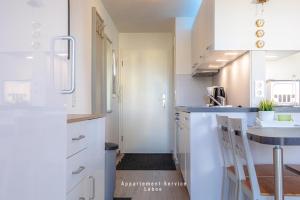 a kitchen with white cabinets and a sink at Kapitänshaus Fewo Seemann Budle in Laboe