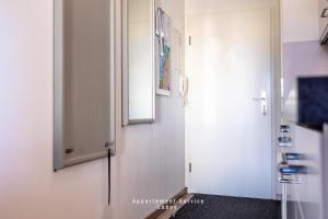 a hallway with a white door and a mirror at Kapitänshaus Fewo Seemann Budle in Laboe