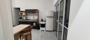 a small kitchen with a stove and a refrigerator at Apartamento modelo chalé 202 in Santo Ângelo