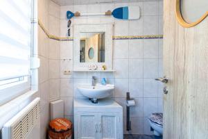 a bathroom with a sink and a mirror and a toilet at Ostseeromantik in Neuhaus +23 photos