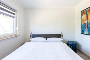 a white bed with two pillows in a bedroom at Ostseeromantik in Neuhaus