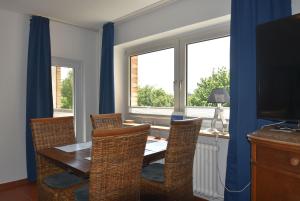 a dining room with a table and chairs and a window at fewo1846 - Ostseebad - Apartment mit 2 Schlafzimmern und Meerblick in Flensburg