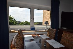 een eettafel met stoelen en een groot raam bij fewo1846 - Ostseebad - Apartment mit 2 Schlafzimmern und Meerblick in Flensburg