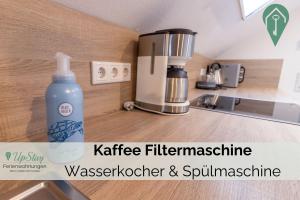 a bottle of water sitting on a kitchen counter at Ferienwohnung Behle in Krummhörn +10 photos