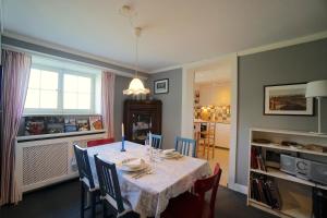 ein Esszimmer mit Tisch und Stühlen in der Unterkunft Ferienwohnung Country Garden - Naturpark Schlei in Güby