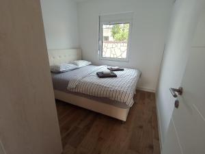 a small bedroom with a bed and a window at Villa Roki in Ravanj