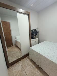 ein Schlafzimmer mit einem Spiegel neben einem Bett in der Unterkunft Casa aconchegante ao lado da Igreja Matriz- Bananeiras-PB in Bananeiras