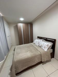 ein Schlafzimmer mit einem großen Bett in einem Zimmer in der Unterkunft Kitnet 4 in Rio Negrinho