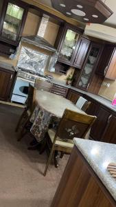 a kitchen with a table and chairs in it at شقه مفروشه مع حديقه اربد بجانب مدارس دار العلوم in Irbid