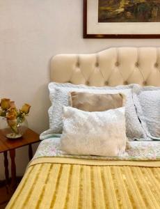 uma cama com uma almofada e uma mesa em Chalé do Vale à 10 min de carro de Itacoatiara em Niterói